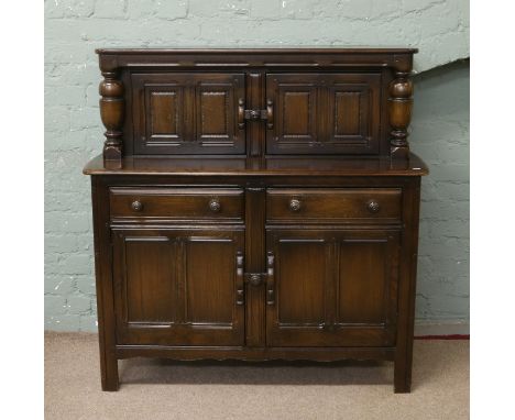 An Ercol dark oak court cupboard.
