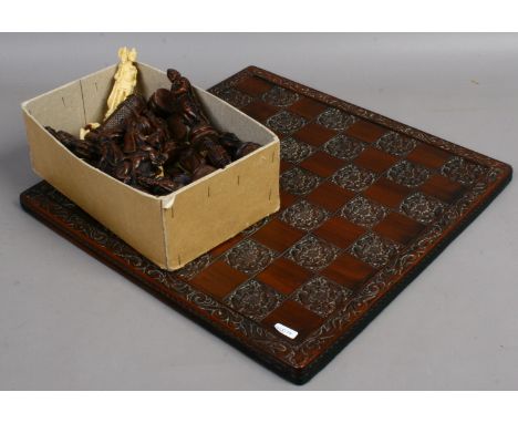 A decorative chess set and board formed as Roman figures.