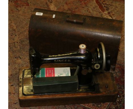 An oak cased Singer sewing machine with accessories and manual 