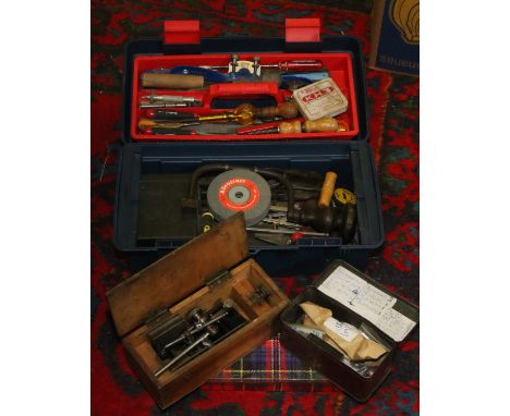A tool box and three tins containing a variety of tools.