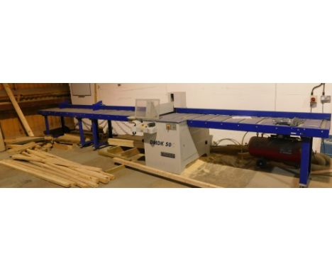 A Rema DMDK-50C cross cut saw with roller platform, the bed being 4.1 metres to the left of the cut and 2.6 metres to the rig