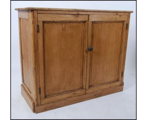 An early 20th century pine school - estate cupboard having plinth base with double doors and shelf space interior. 84cm high 