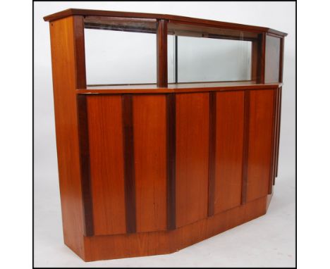 A good 1970's retro teak wood Danish influence cocktail drinks bar having glass display shelf over panelled facia. Curtains t