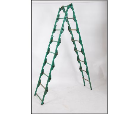 A 1950's painted tubular metal Industrial A-Frame ladder having original green paint with the slats matching either side idea