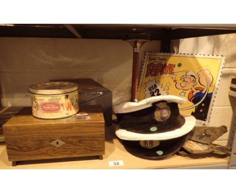 Shelf of mixed items including boxes and Royal Navy caps