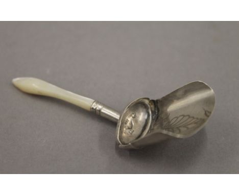A silver and mother-of-pearl caddy spoon. 7 cm long.