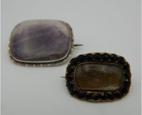 A 19th century unmarked gold mourning brooch and an amethyst set silver brooch. The former 2 cm wide.