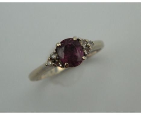 An 18 ct white gold diamond and ruby ring. Ring size K. 2.8 grammes total weight.