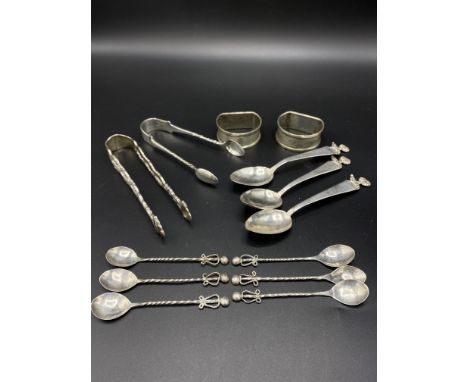 Two engine turned silver napkin rings; pair of silver sugar tongs; three white metal spoons; six white metal coffee spoons; w