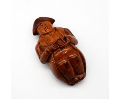 A late 18th/early 19th century Napoleonic era novelty figural coquilla nut snuff box, carved as possibly Napoleon himself, in