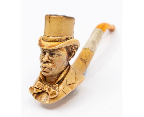 A late 19th Century silver mounted Meerschaum pipe carved as a bust of a Gentleman with top hat, cravat and amber mouth piece