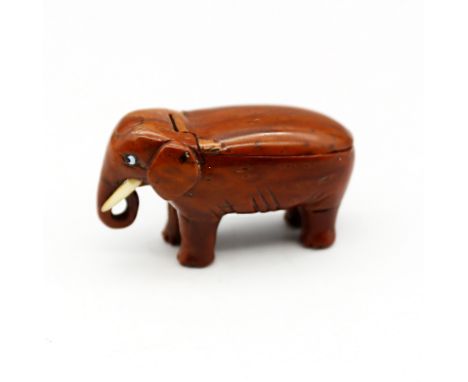 A late 18th/early 19th century carved coquilla nut snuff box, carved as an elephant, small glass eyes and bone tusks, the hin
