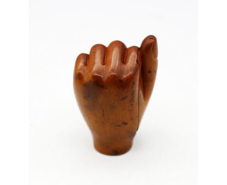 A late 18th/early 19th century carved boxwood snuff box, in the shape of a clenched fist, the thumb area hinged opening to sh