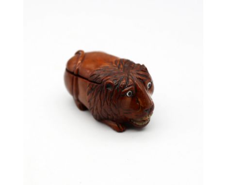 A late 18th/early 19th century carved coquilla nut snuff box, in the shape of a lion, glass eyes and mother of pearl teeth wi