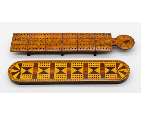 An Edwardian inlaid wooden rectangular cribbage board with curved ends, on four stilted feet, geometric design in satin and o
