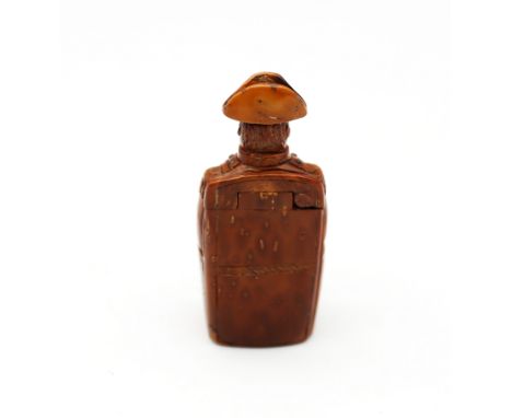 A late 18th/early 19th century Napoleonic era carved coquilla nut figural snuff box, carved as possibly Napoleon sitting on s