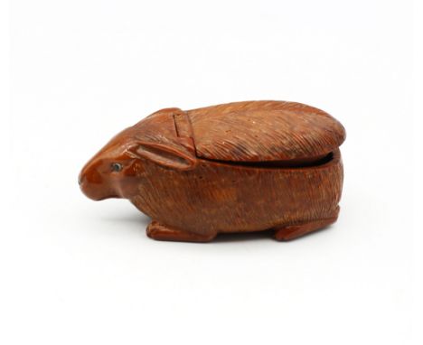 A late 18th/early 19th century carved coquilla nut snuff box, in the shape of a rabbit, glass bead eyes and hinged snuff comp