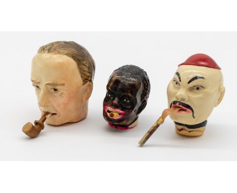 Three novelty 20th century plastic measuring tapes modelled as male heads: one smoking a pipe, the other two smoking cigarett