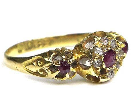 An 18ct gold, ruby and diamond ring, with central rose cut ruby surrounded by seven old cut diamonds, a/f one missing, and tw