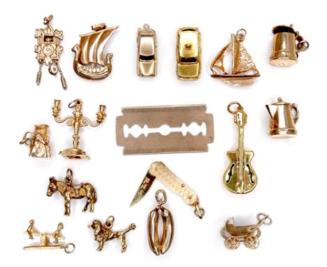 A group of seventeen 9ct yellow gold charms, comprising folding pen knife, candelabra, razor blade, pair of bananas,  violin,