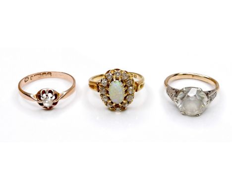 A group of three rings, comprising an 18ct gold ring set with an oval opal, approximately 8.5 by 5.0mm, surrounded by twelve 