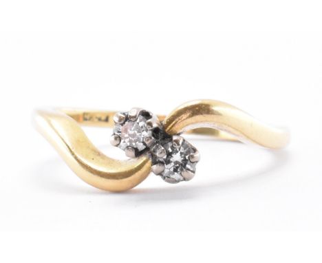 A hallmarked 18ct gold crossover ring. The ring being set with two round cut diamonds. Diamonds measure 2.7mm diameter. Hallm