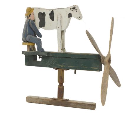 An American folk art wind vane,with a double propeller, of a man milking a cow, 38cm wideFrom the collection of David Pocknel