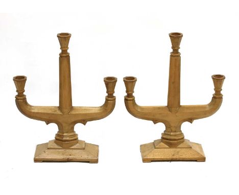 A pair of fruitwood three-branch candelabra,each with flared faceted sconces and a chamfered support, 32cm wide40.5cm high (2