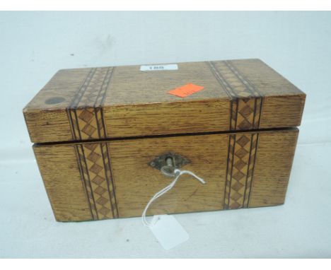 A vintage treen tea caddy in oak with marquetry inlay and original key