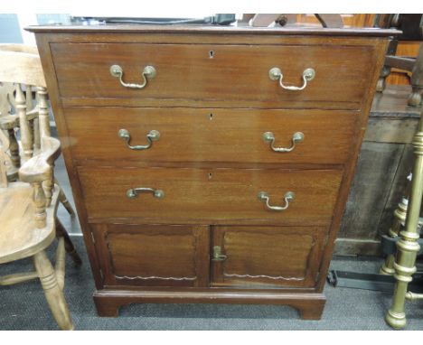 An early 20th century mahogany chest of three long drawers with cupboard under, on bracket plinth base