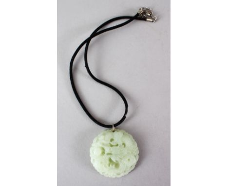 A 19TH / 20TH CENTURY CHINESE CARVED GREEN JADE PENDANT OF A DRAGON, the dragon carved in floing motion amongst laming pearl 