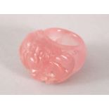 A GOOD CHINESE CARVED ROSE QUARTS DRAGON RING, the ring carved with a dragon upon flaming pearl,