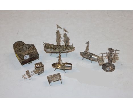 A white metal filigree miniature grand piano and stool; together with other Chinese miniature white metal figures and boats 