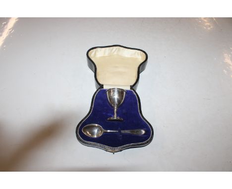 A cased silver egg cup and spoon