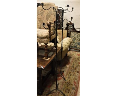 A 20th Century pair of black painted wrought iron five-light candlestands on open barley twist decorated column supports to t