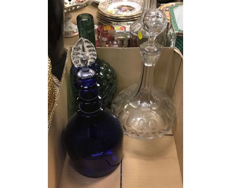 A box containing a collection of four decanters including a pair of green glass grape and vine bottle-shaped decanters, a Bri