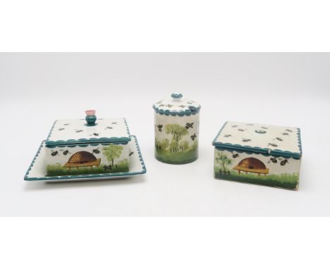 A Wemyss ware honey box and cover with stand, another honey box and cover and a cylindrical honey pot and cover all decorated