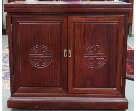 A 20th century Oriental hardwood bar/drinks cabinet with folding counter top over pair of cabinet doors concealing fitted int