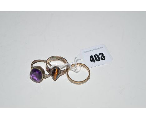An amethyst ring; a cat's eye ring; and a white stone eternity ring, in 9ct. white and yellow gold.