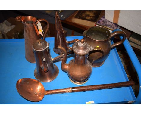 A collection of copperware, including: an ale mulling jug; two copper jugs; a copper ladle with wooden handle; and two copper