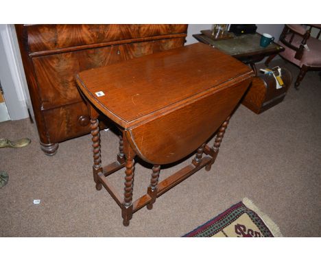 An oak drop leaf table, the barley twist legs fitted gate action.
