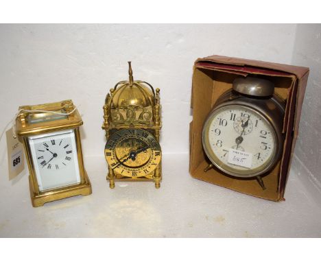 A brass French carriage clock with roman numerals, white enamel dial; together with a baby No. 5 alarm clock, in original box