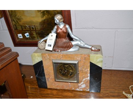 An Art Deco onyx and marble mantel clock, mounted by silvered and patinated female figure.