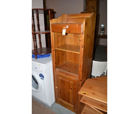 A stained pine cabinet, with single drawer above alcove fitted shelf a panel door under; together with a three tier dark stai