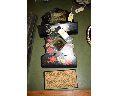 Two papier mache black lacquered wall pockets with hand-painted decoration, one fitted a mirror, the other with a hinged cove