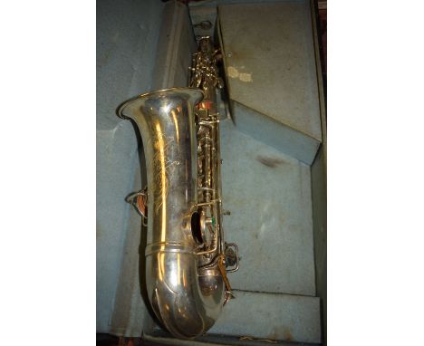 An electroplated saxophone inscribed 'Perfect First Class'; with mouthpiece and accessories, in fitted case.