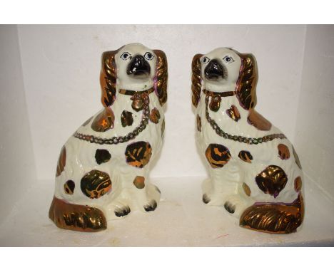 A pair of late 19th Century Staffordshire ceramic seated dogs, with copper lustre decoration and painted faces.
