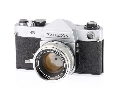A Yashica J-5 35mm SLR Camera and "Tomioka" lens silver camera, shutter curtain misaligned, slow speeds slightly off, light m