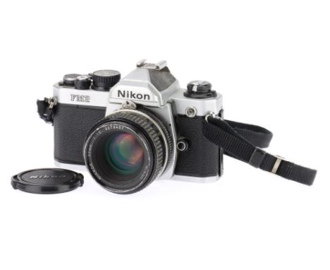 A Nikon FM2 35mm SLR Camera silver, body F-G with some rubbing marks from use, shutter speeds all work, internal metering dis