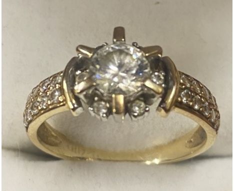 9ct yellow gold ring set with large cubic zikonia central stone surrounded by 6 smaller stones set with cubic zikonia shoulde